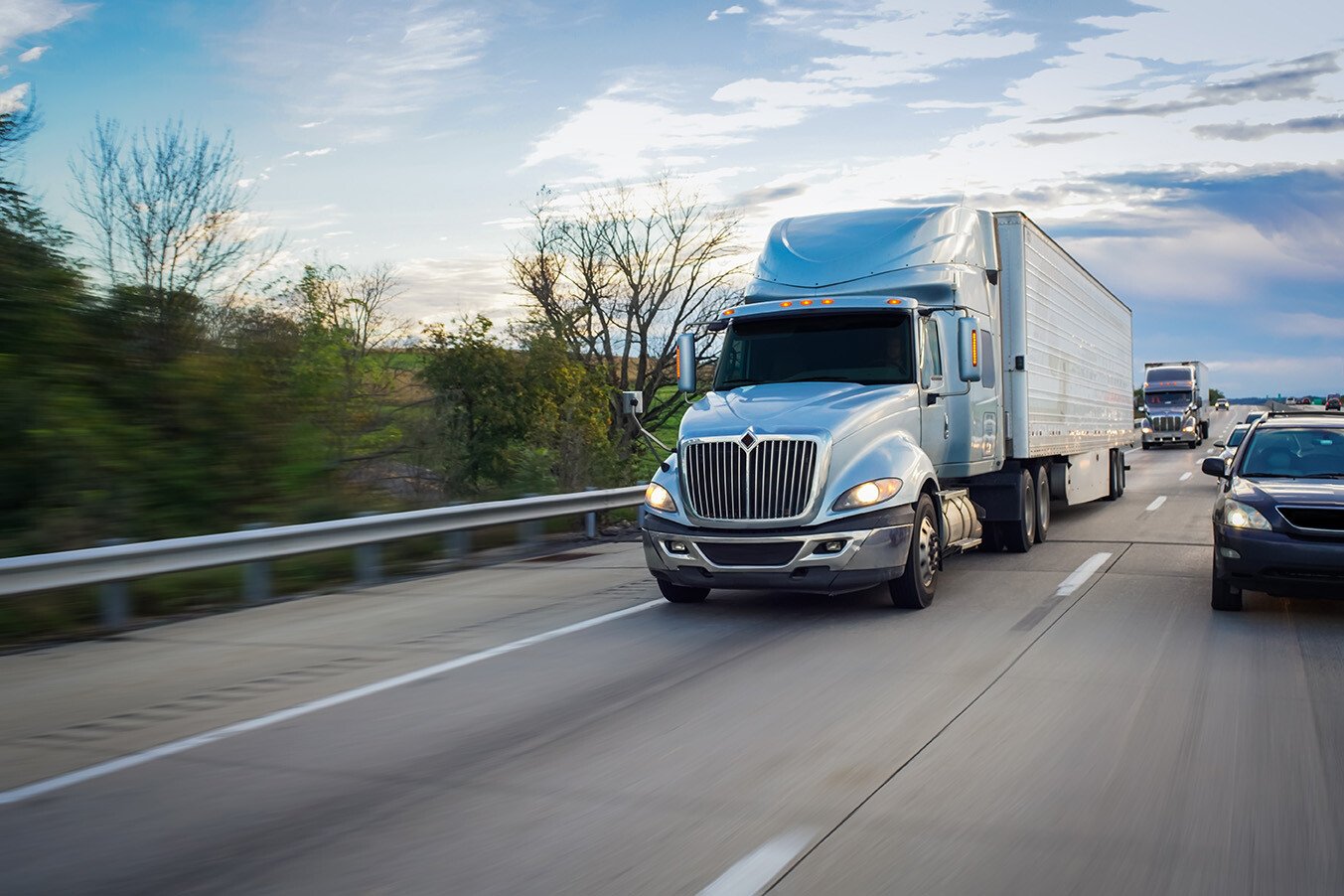 A hot shot trucking rig travels along a busy highway